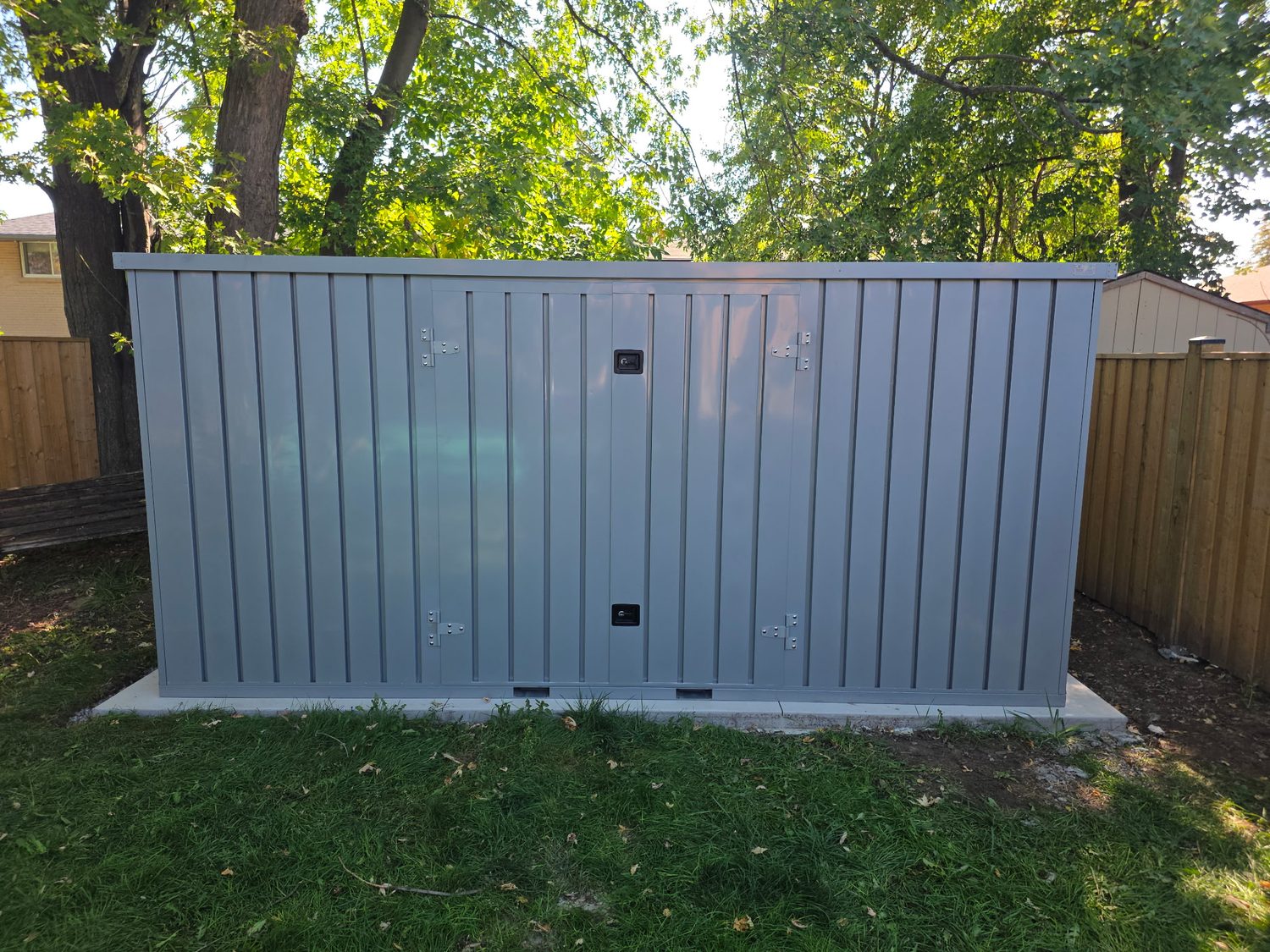 Slate grey My Yard Vault 4 Corners on a backyard concrete slab under shade trees