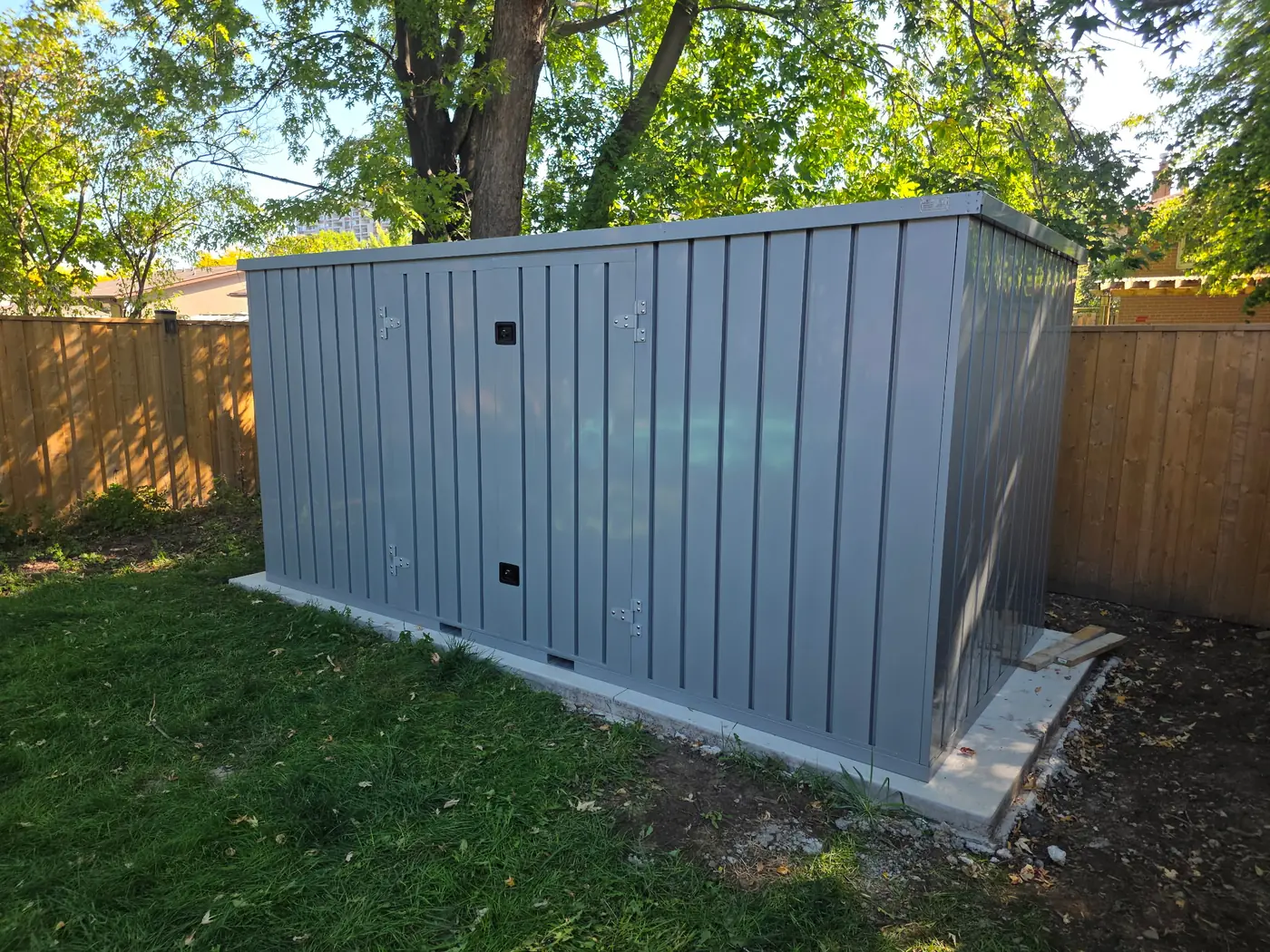 Galvanized steel My Yard Vault 4 Corners tucked into a fenced backyard