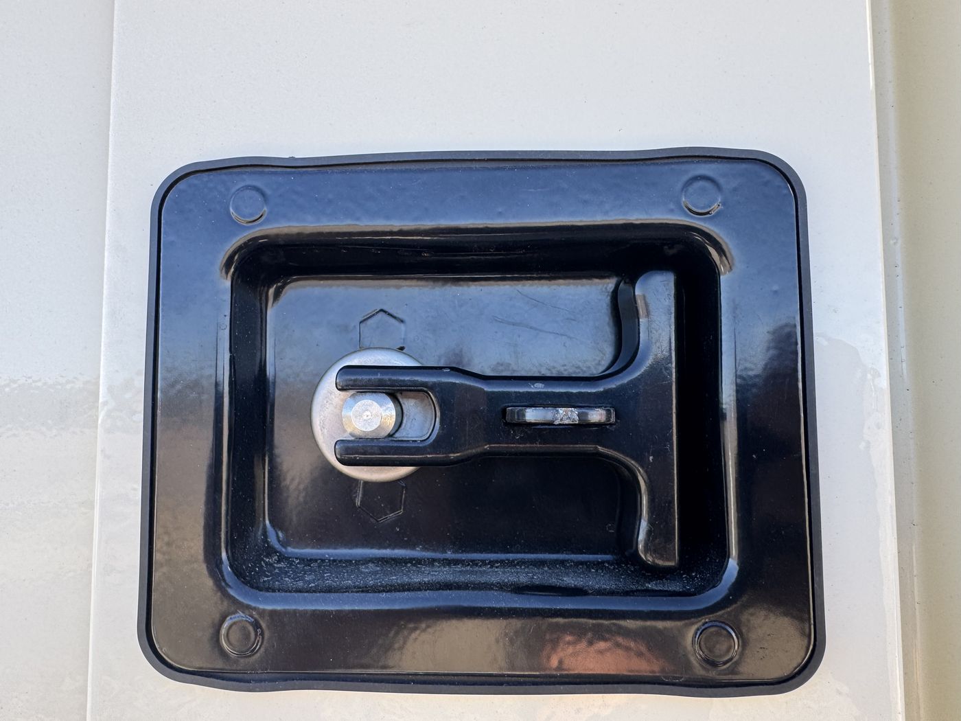 Flush recessed paddle latch, lockable and weather-sealed.